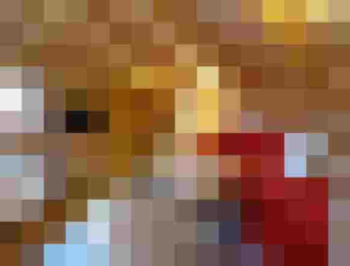 Gemütliches Wohnzimmer mit Holzverkleidung, rotem Sofa und TV in der Pension Bäckenhäusl.